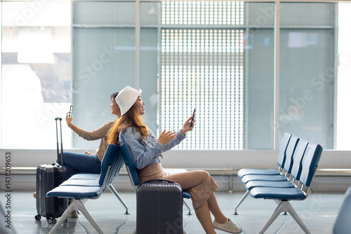 Obraz na płótnie Happy Asian Woman waiting for flight at airport lounge. Happy asian woman passenger traveler waiting for departure with suitcase at modern airport terminal w salonie