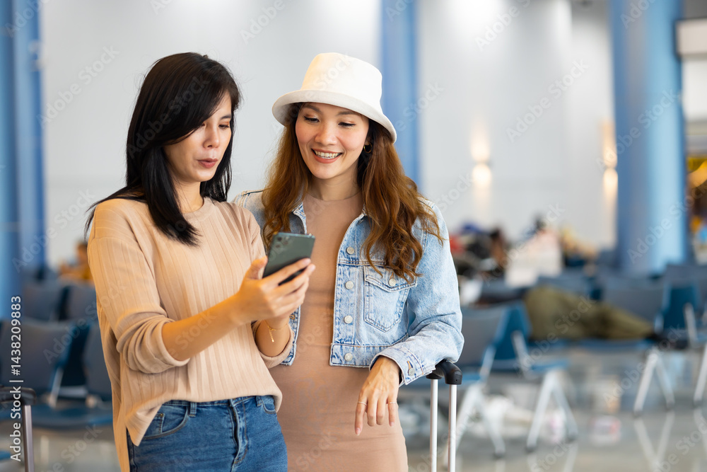 Internet Online Check flight schedule on smartphone. arrival and departure board. Two Asian woman use smartphone cheking flight for travel in long weekend