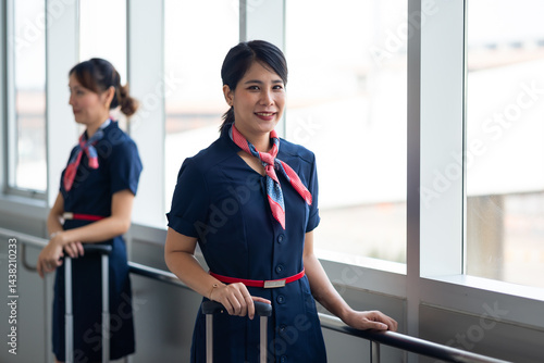 Obraz na płótnie Portrait female Cabin crew or air hostess in airport. Cabin crew, air hostess working in airplane. Service mind. Asian stewardess with suitcase at modern airport terminal. flight attendant w salonie