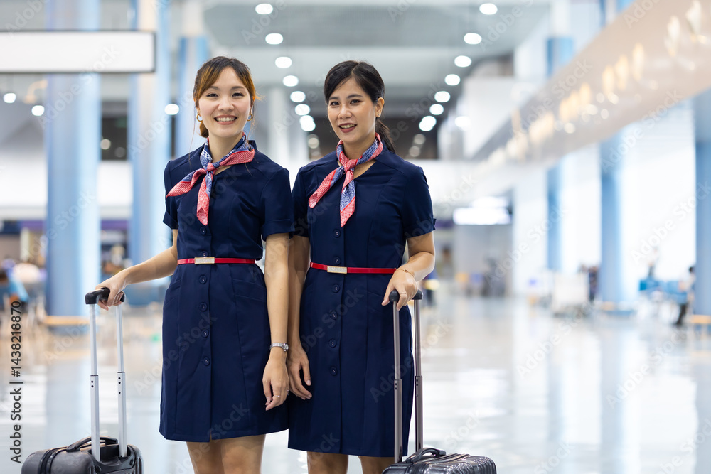 Portrait two Cabin crew or air hostess in airport. Cabin crew, air hostess working in airplane. Service mind. Asian stewardess with suitcase at modern airport terminal. flight attendant