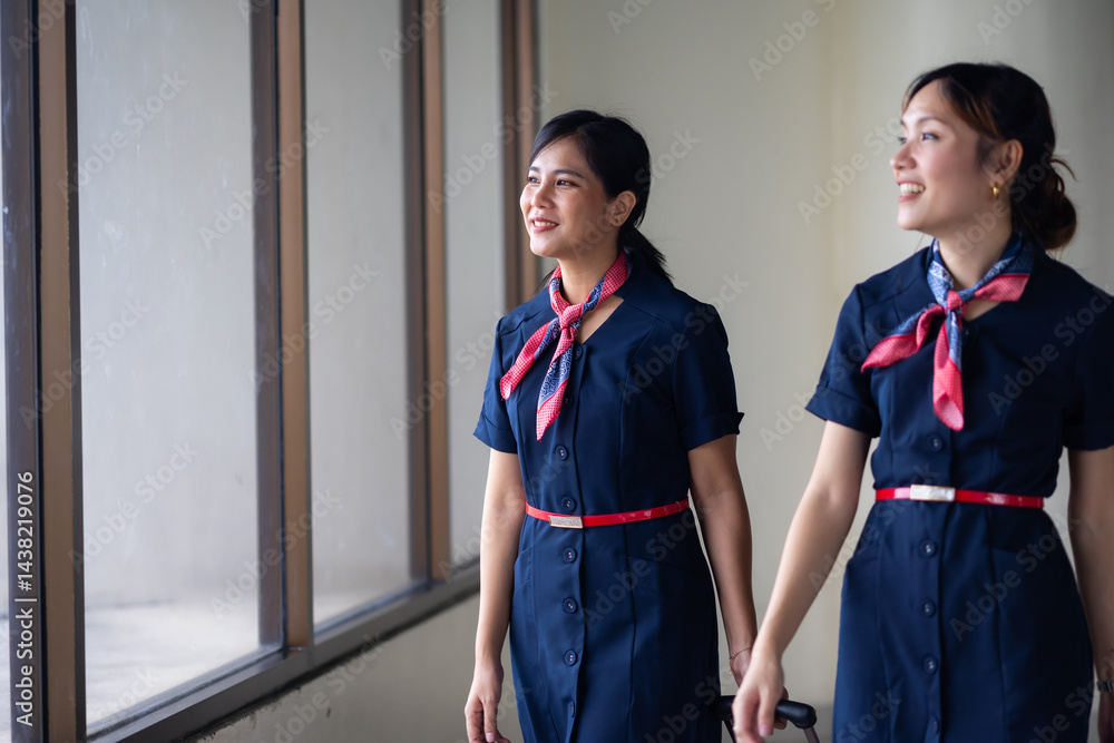 Portrait two Cabin crew or air hostess in airport. Cabin crew, air hostess working in airplane. Service mind. Asian stewardess with suitcase at modern airport terminal. flight attendant