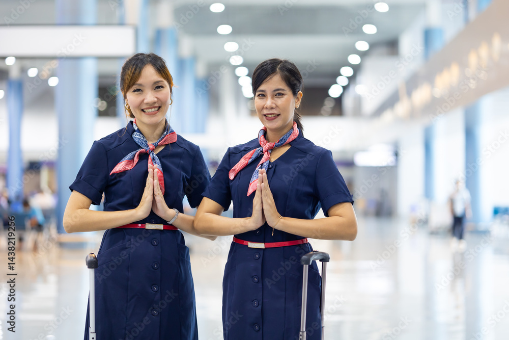 Portrait two woman friends sawasdee thai hello in airport. Cabin crew, air hostess working in airplane. Service mind. Asian stewardess with suitcase at modern airport terminal. flight attendant