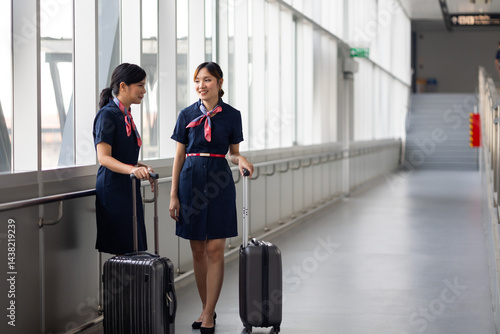 Obraz na płótnie Portrait two Cabin crew or air hostess in airport. Cabin crew, air hostess working in airplane. Service mind. Asian stewardess with suitcase at modern airport terminal. flight attendant w salonie