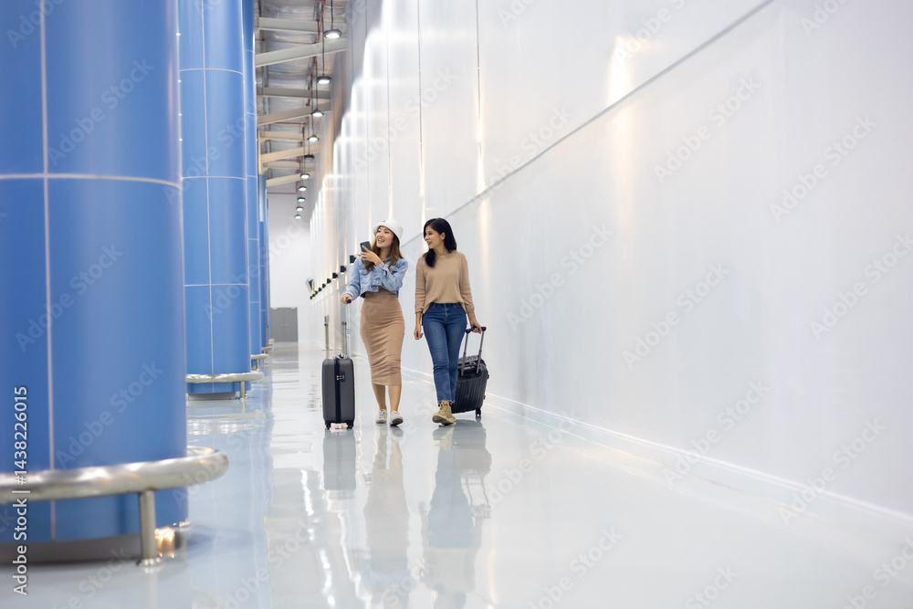 Two Happy Asian Female Friends Travelling Together. Happy asian woman passenger traveler waiting for departure with suitcase at modern airport terminal