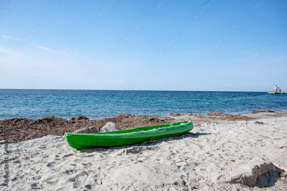 Kayak on the sand, abandoned kayak on the seashore