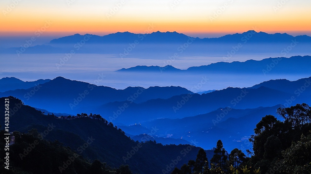 Fototapeta premium Misty mountain range at sunrise. Layers of blue mountains covered in morning mist