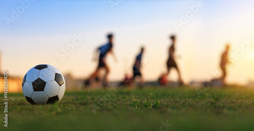 Action sport outdoors of kids having fun playing soccer football for exercise in community rural area under the twilight sunset sky.