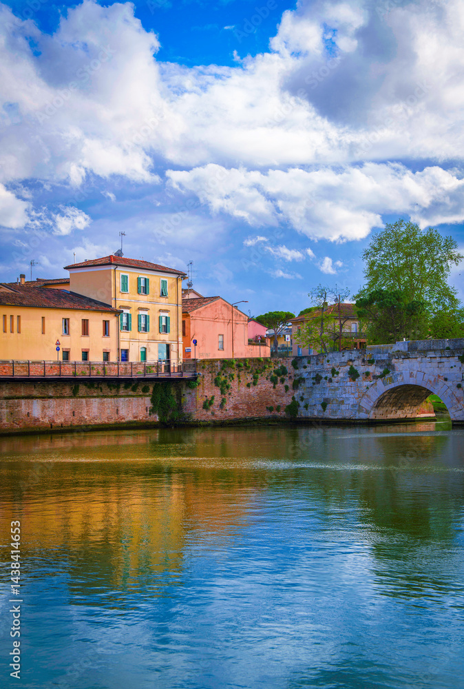 Obraz premium Beautiful Rimini city skyline and landscape over the landmark bridge Ponte di Tiberio and the Marecchia River in the Emilia-Romagna region of Italy, blending ancient charm with scenic beauty