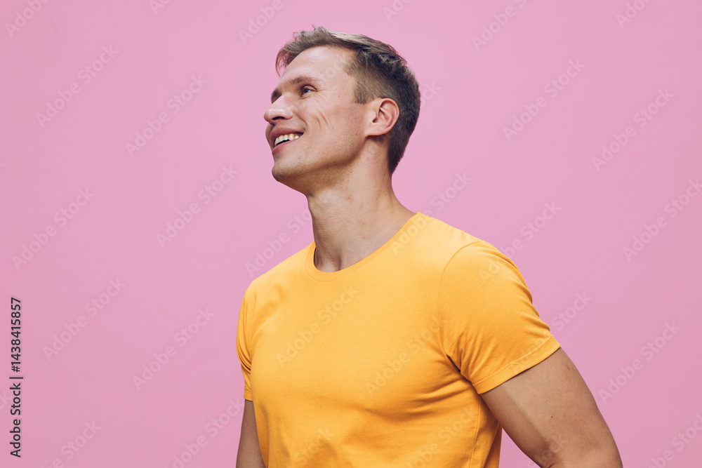 smiling man wearing yellow t-shirt looking side up happy cheerful casual studio portrait pink background digital nomad concept smiling man wearing yellow t-shirt looking side up happy cheerful casual studio portrait pink background digital nomad concept