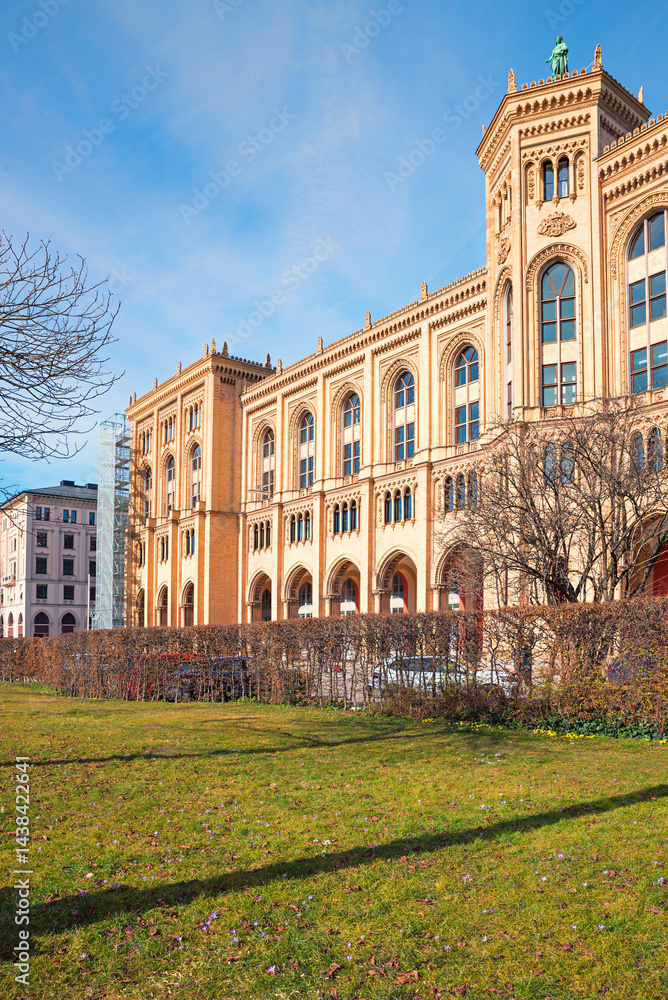 frontside of historic government building of upper bavaria, in april, green meadow