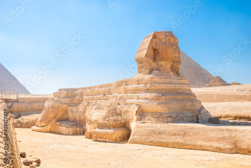 majestic Egyptian sphinx against the backdrop of ancient pyramids under the scorching sun of the Sahara desert. Cairo
