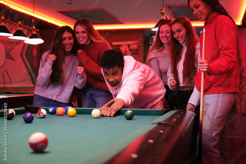 Group of friends playing pool in a pub, having fun together