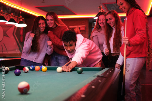 Obraz na płótnie Group of friends playing pool in a pub, having fun together w salonie