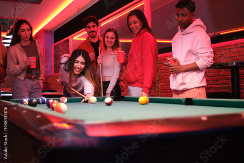 Obraz na płótnie Group of friends enjoying a night out playing pool and having drinks in a trendy nightclub w salonie