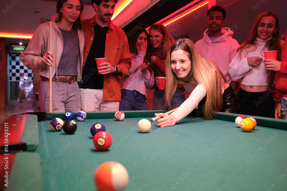 Group of friends having fun playing pool in a pub, enjoying their evening together