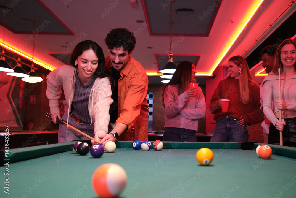 Group of friends enjoying a game of pool in a lively nightclub