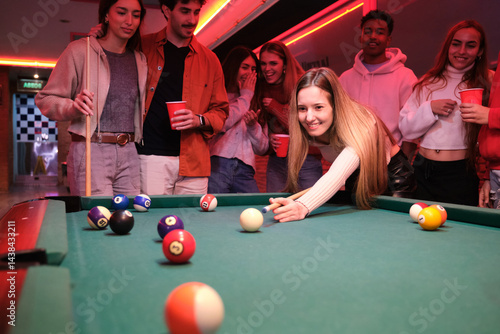 Obraz na płótnie Group of friends having fun playing pool in a pub, enjoying their evening together w salonie