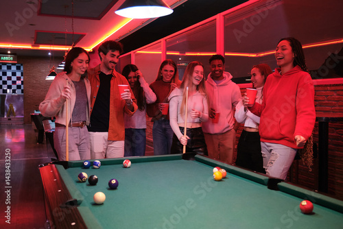Obraz na płótnie Young people enjoying a game of pool and drinks at a vibrant pub, celebrating friendship and leisure time w salonie