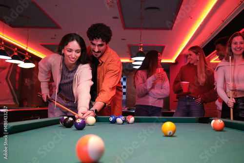 Obraz na płótnie Group of friends enjoying a game of pool in a lively nightclub w salonie