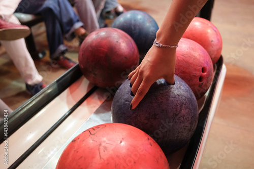 Obraz na płótnie Hand of a woman choosing a bowling ball in a bowling alley, ready to play w salonie