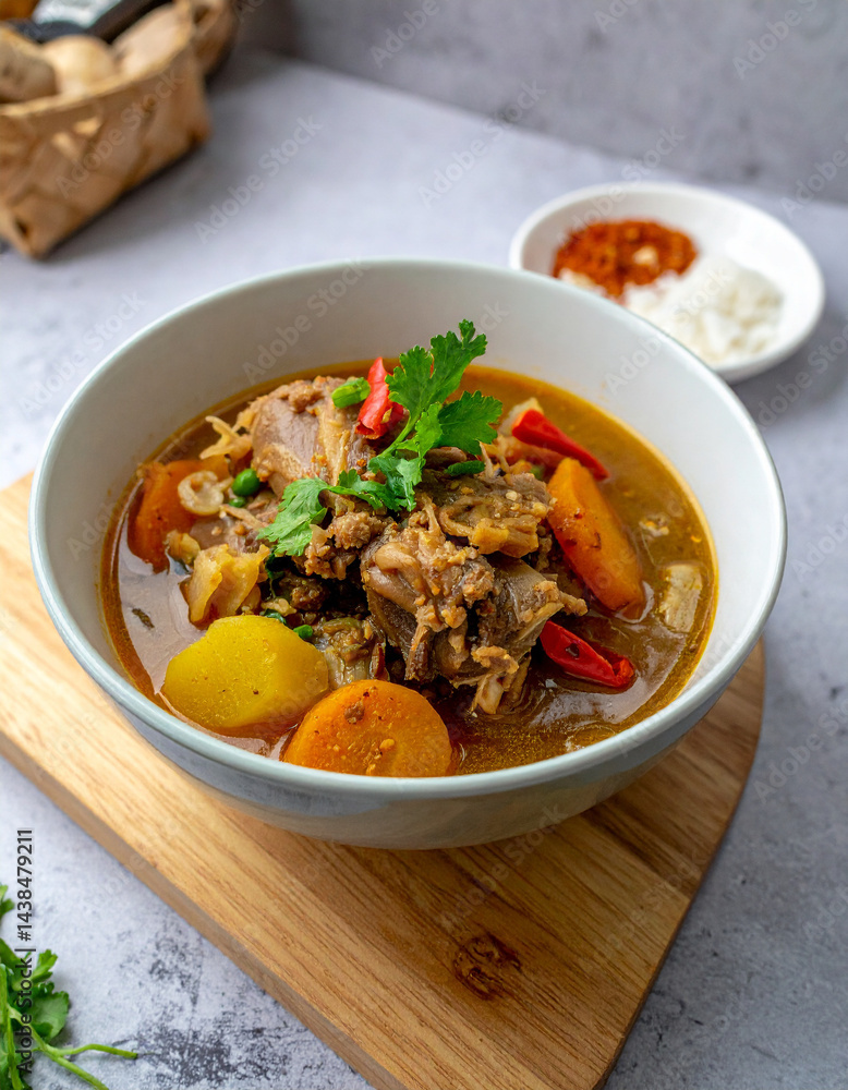 A steaming bowl of flavorful paya, a slow-cooked trotter stew with rich broth and spices, a traditional and hearty winter dish. A steaming bowl of flavorful paya, a slow-cooked trotter stew with rich broth and spices, a traditional and hearty winter dish.