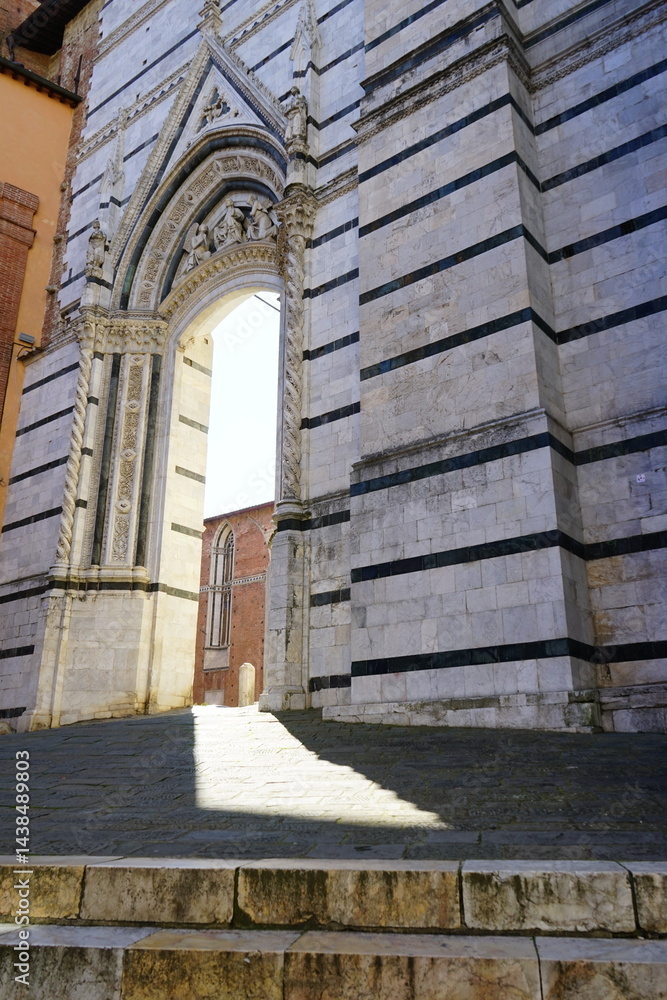 Fototapeta premium Filtering light through a gate nearby Siena Cathedral, Tuscany, Italy