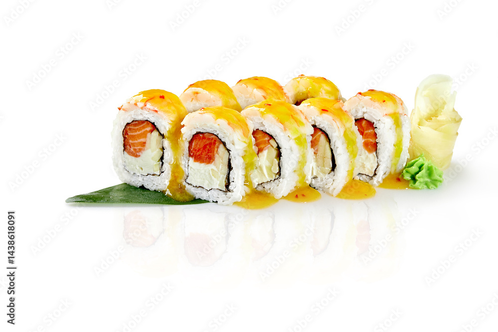 Sushi rolls covered with mango sauce resting on a bamboo leaf