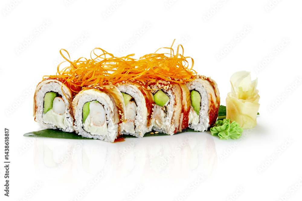 Sushi rolls with eel, avocado, cream cheese, shrimp and sesame seeds lying on a banana leaf