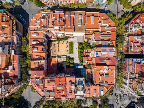 Aerial view of Eixample district in Barcelona, Spain, with red rooftops, green courtyards, and symmetrical grid streets.