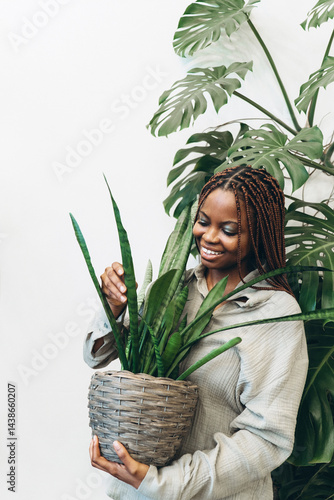 Obraz na płótnie A woman lovingly nurturing her indoor plant in a beautifully arranged natural greenery setting w salonie