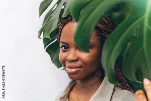 A beautiful woman surrounded by lush tropical plants in a calm and serene environment
