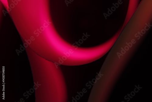 Papel de color para regalos, borroso formando aros y curvas geométricas forma un original diseño abstracto con fondo negro.