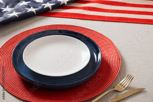 Table setting for USA Independence Day. Festive dinner with empty plate and decoration in USA national flag colors. Happy Memorial Day. Close up.