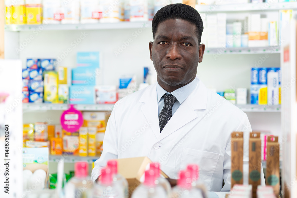 Portrait of an african american male pharmacist standing in the sales hall of a pharmacy. Close-up portrait Portrait of an african american male pharmacist standing in the sales hall of a pharmacy. Close-up portrait