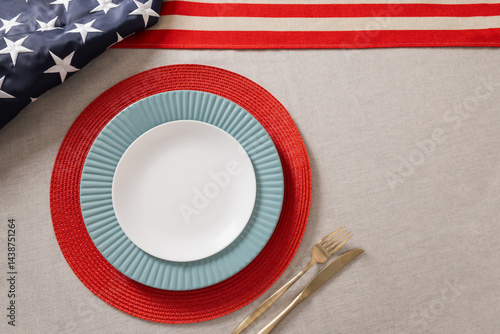 Table setting for USA Independence Day. Festive dinner with empty white plate and decoration in USA national flag colors red and blue. View from above. Copy space. Close up.