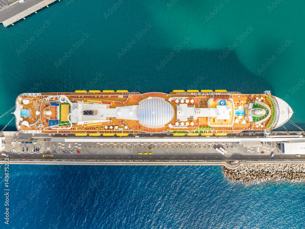Cruise ship sailing in the azure waters off Funchal, Madeira, showcasing luxury and adventure on a sunny day