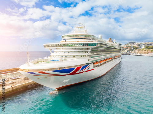 Luxurious cruise ship sails through crystal clear waters under a bright blue sky, offering an unforgettable vacation experience at sea