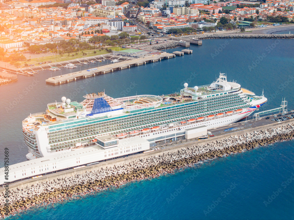 Explore the beauty of a luxurious cruise ship anchored in serene waters while surrounded by a vibrant coastline