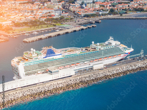 Obraz na płótnie Explore the beauty of a luxurious cruise ship anchored in serene waters while surrounded by a vibrant coastline w salonie