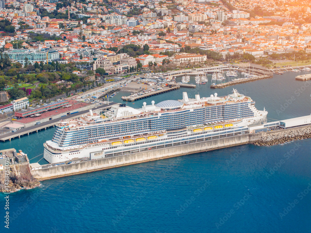 Majestic cruise ship docked near a vibrant coastal city under bright sunlight