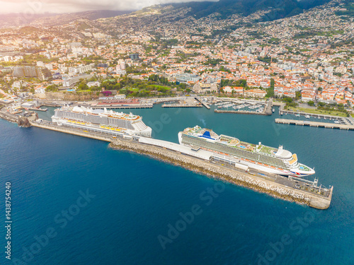 Cruise ships anchor in vibrant harbor, surrounded by stunning coastal city and clear blue waters during a sunlit afternoon