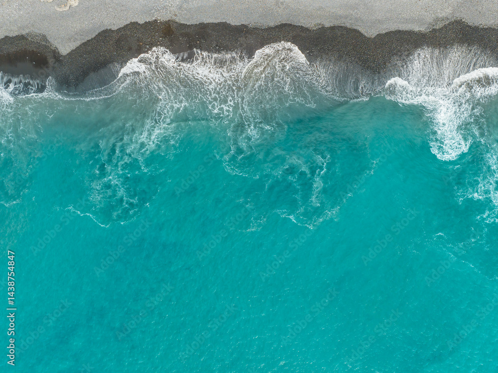 Turquoise waves gently lap against the sandy shore under a radiant sunny sky in a serene coastal escape