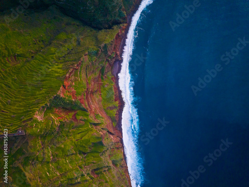 Obraz na płótnie Breathtaking aerial view of the lush coastline meeting the deep ocean at sunrise w salonie
