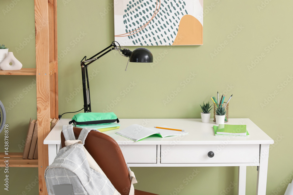 Workplace with school stationery and backpack in children's room