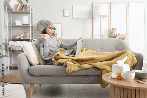 Sick young woman with lapto...