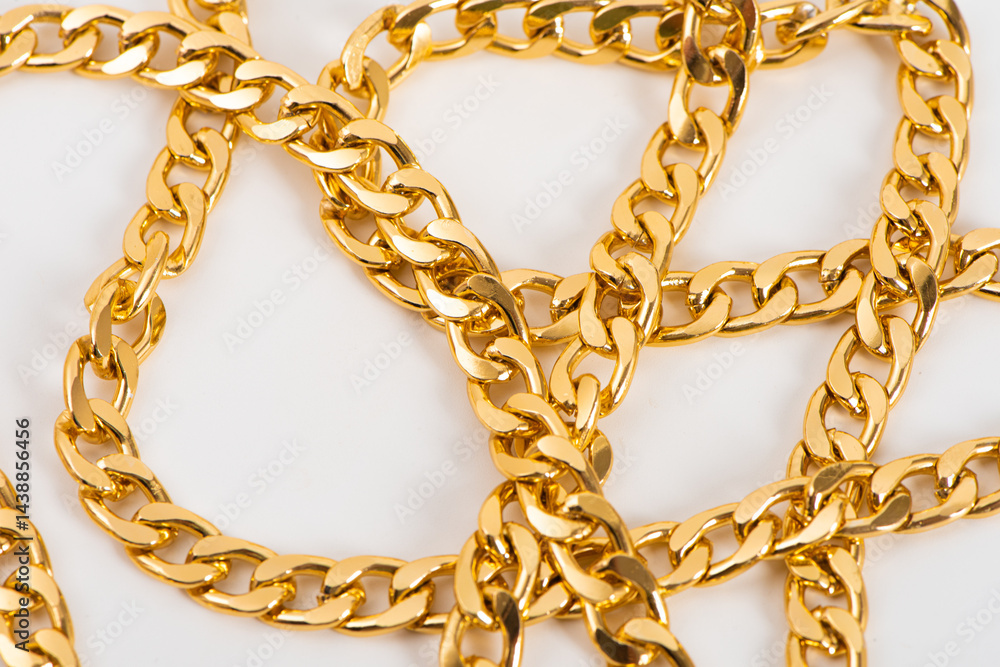 closeup of gold jewelry chains set on white background.