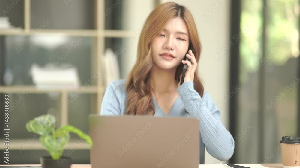 Asian businesswoman sitting using her phone while working and talking to customers online. Asian businesswoman sitting using her phone while working and talking to customers online.