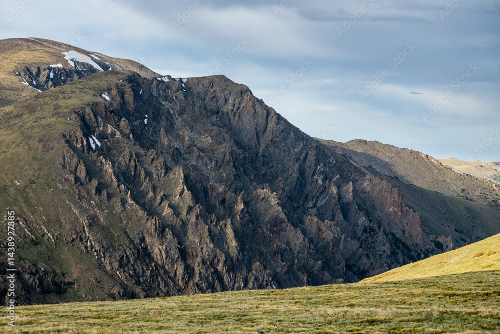 Looking Acros Green Tundra Field Toward Jagged Mountain Side