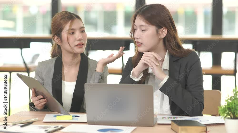 Asian businesswoman sitting at work using laptop talking and consulting in office Asian businesswoman sitting at work using laptop talking and consulting in office