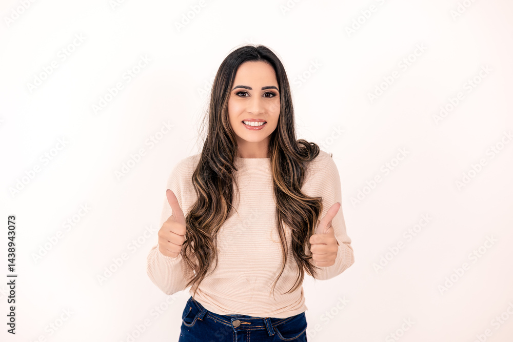 young woman, student, long dark wavy hair, on a white background with two fingers raised up in a thumbs up sign, smiling, approving young woman, student, long dark wavy hair, on a white background with two fingers raised up in a thumbs up sign, smiling, approving